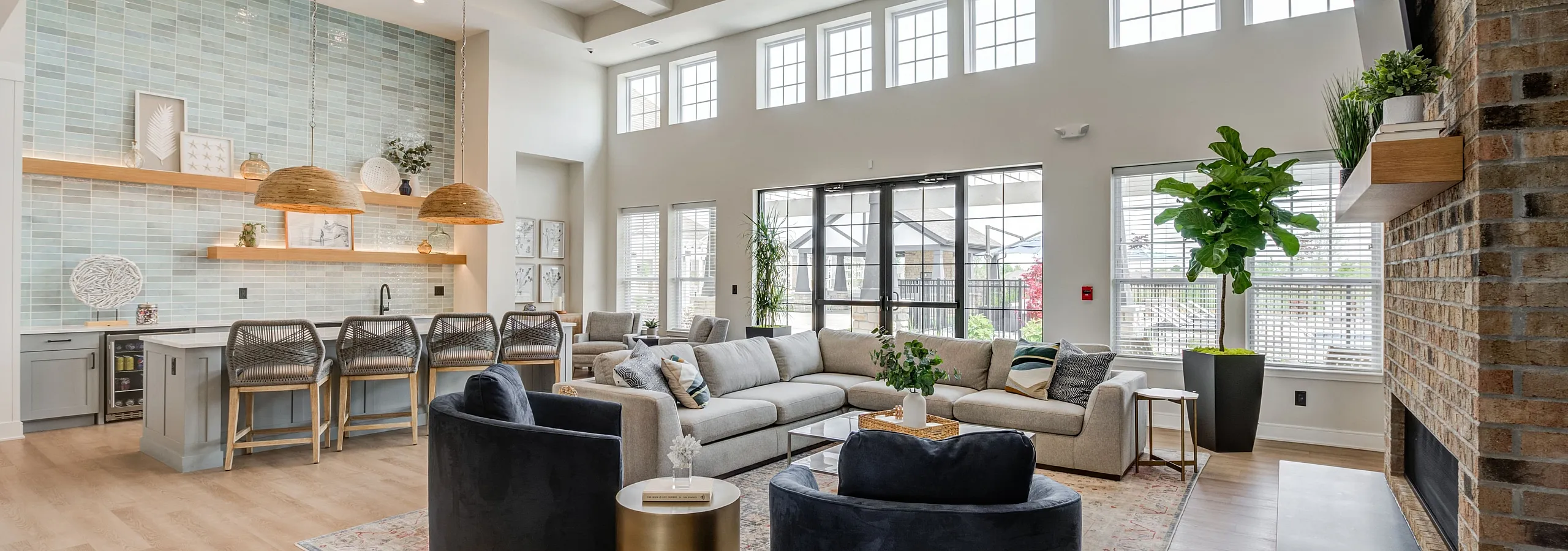 Bright and airy living space with high ceilings, modern kitchen, large windows, and cozy seating, perfect for relaxation and entertaining.