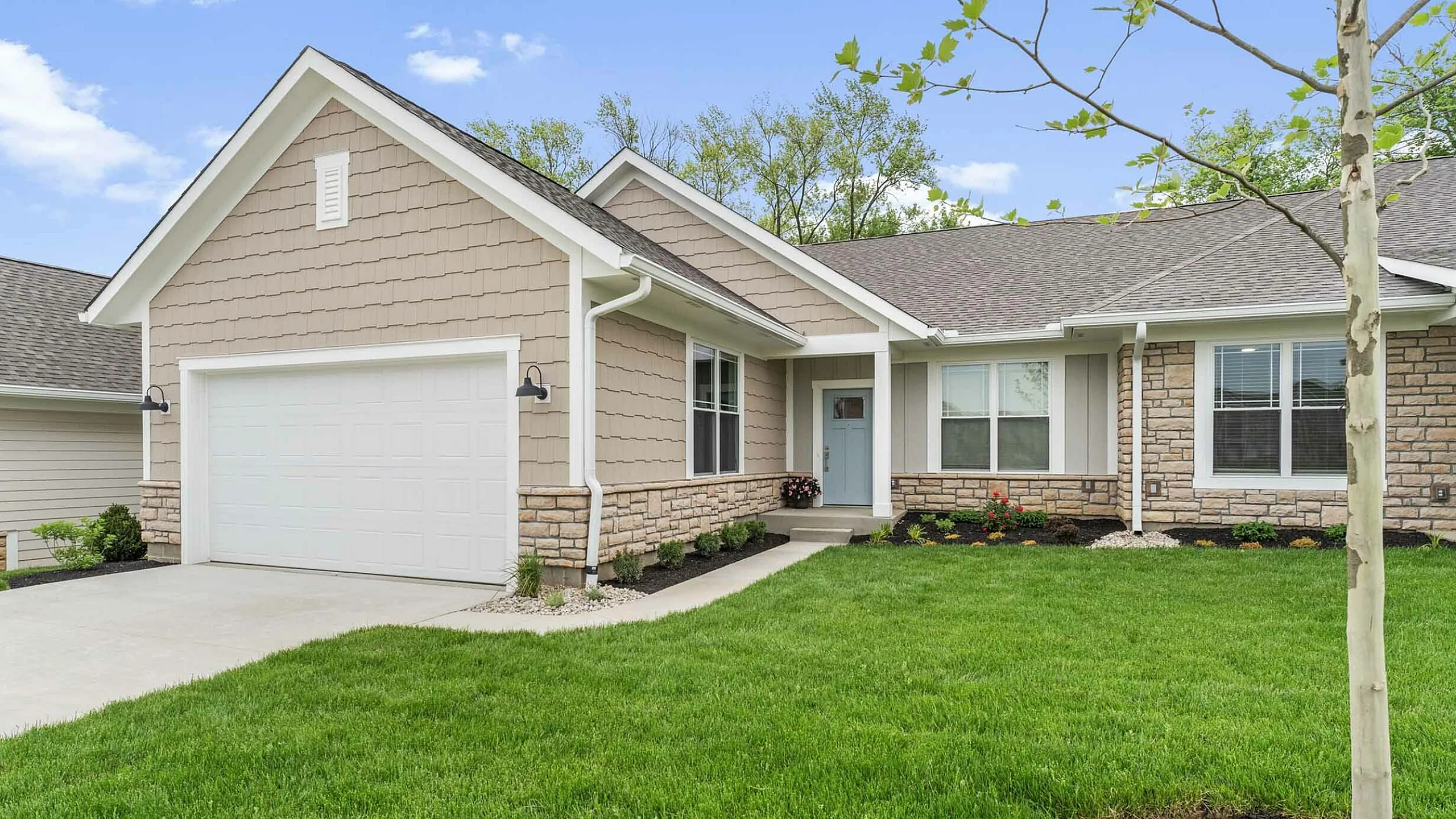 Charming single-story home with stone accents, a spacious front yard, and inviting entrance.