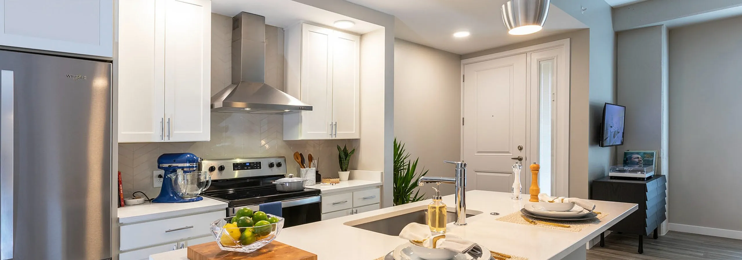 Modern kitchen design with sleek stainless steel appliances, elegant pendant lighting, and a stylish island countertop with two place settings.