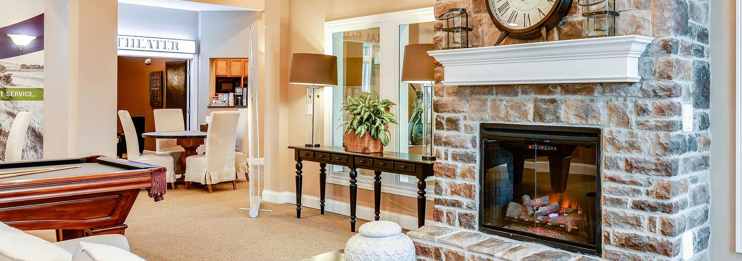 Inviting living space with a cozy stone fireplace, elegant seating area, and stylish pool table.