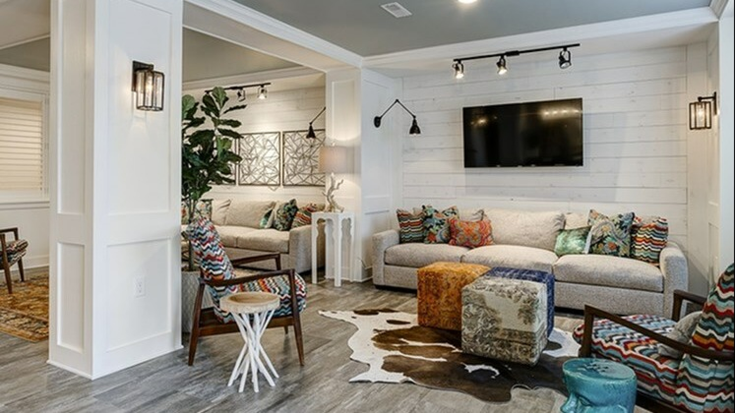 Chic living room with cozy seating, vibrant cushions, modern decor, and TV, perfect for relaxing.