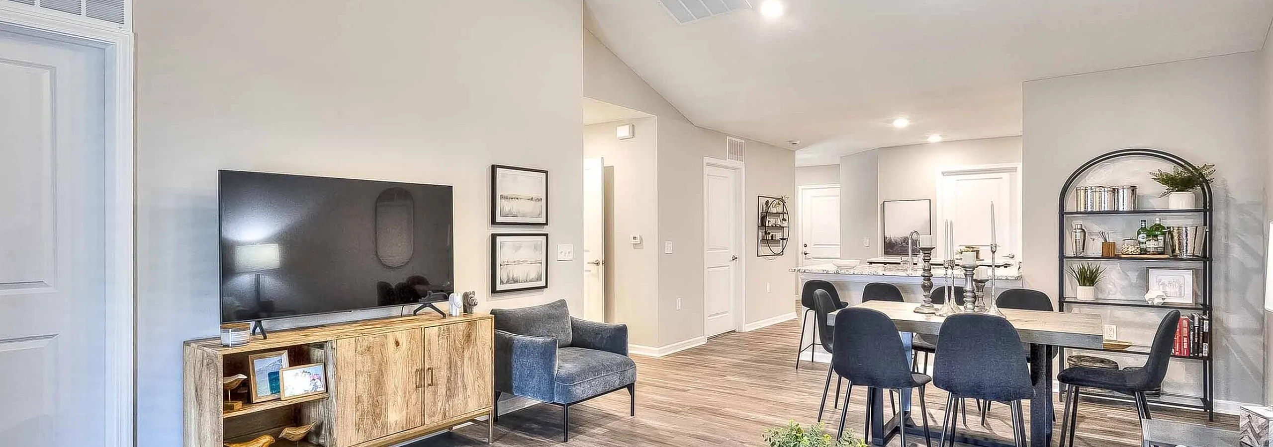 Chic open-concept living room with contemporary furnishings, large dining area, and warm hardwood floors, perfect for modern living.