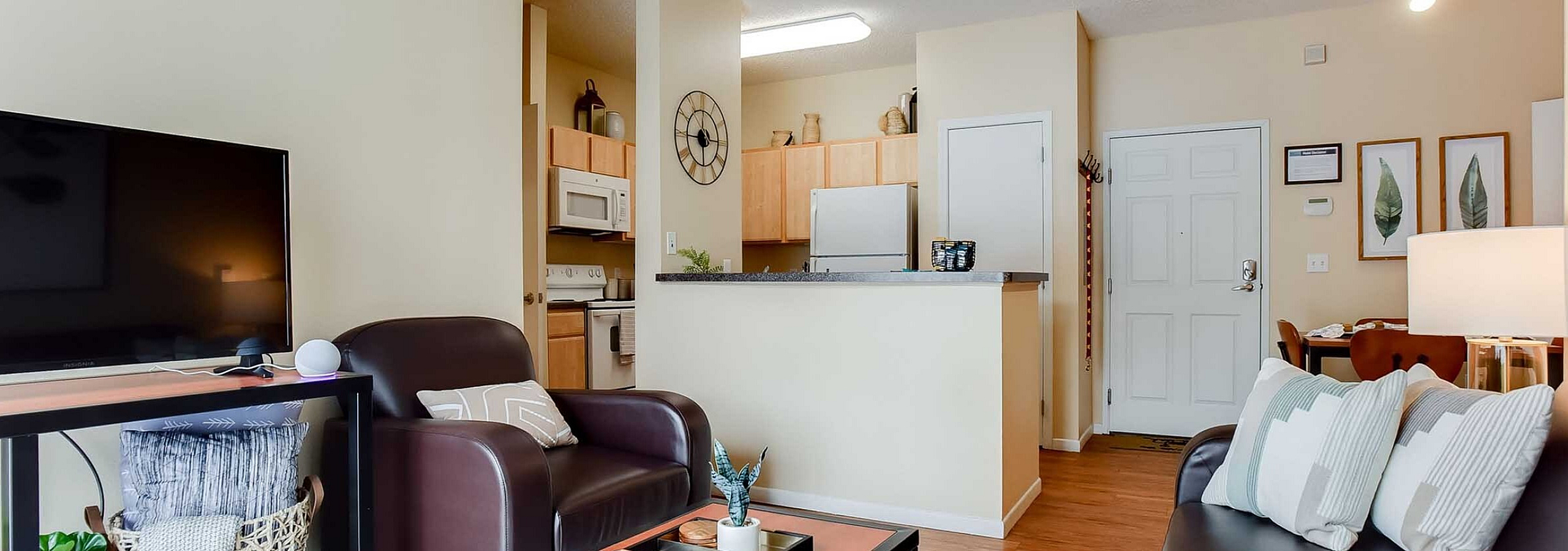 Inviting open-plan living area with modern kitchen, chic decor, and comfortable seating in a stylish apartment.