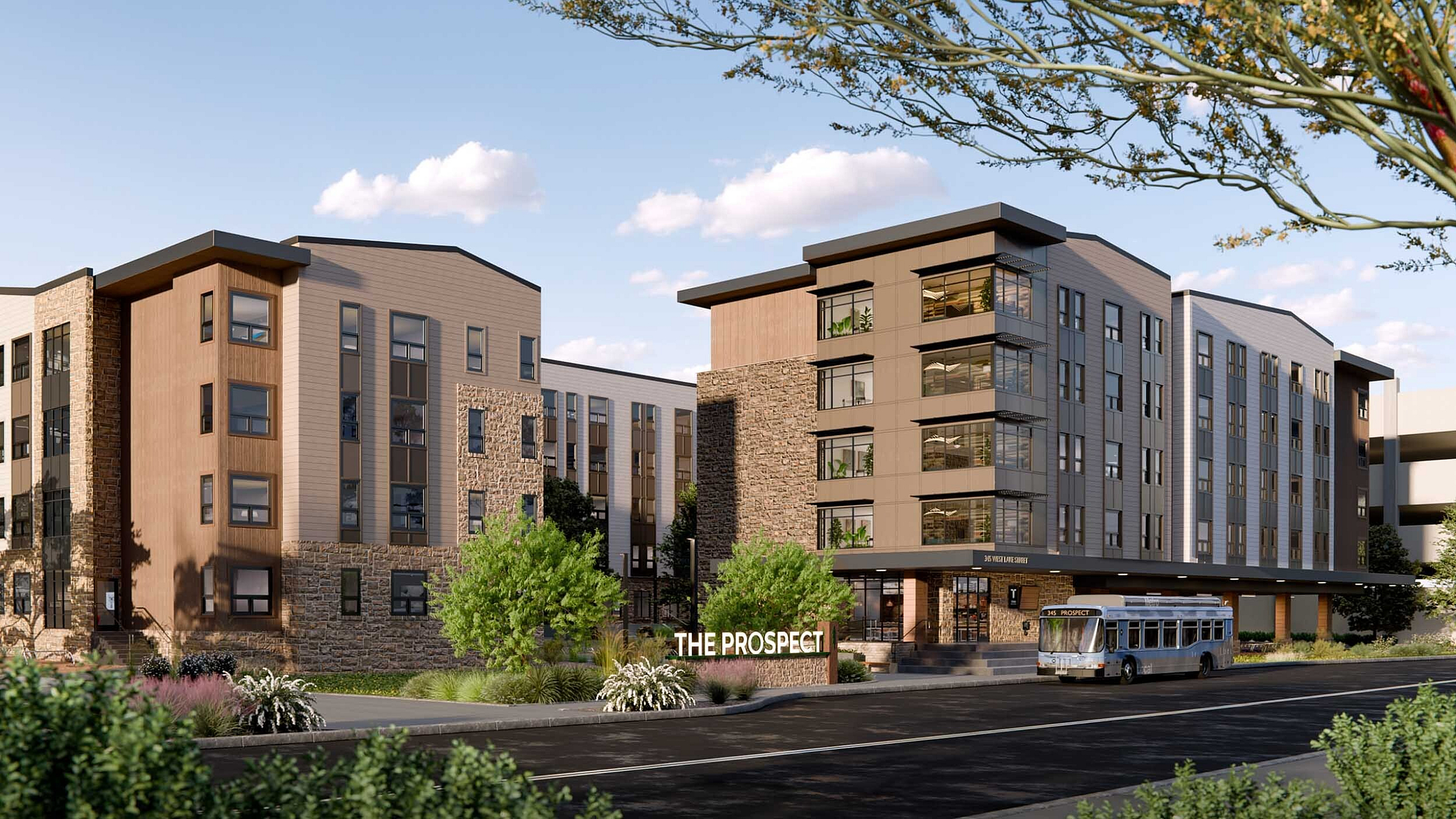 Contemporary apartment complex with modern architecture and lush landscaping, featuring natural stone and wood accents at The Prospect.