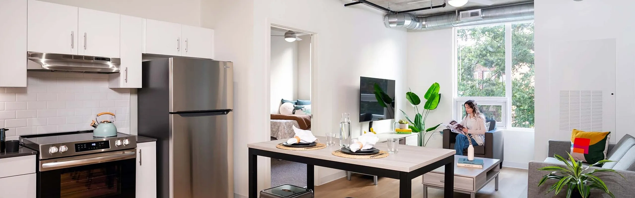 Modern open-concept apartment featuring a sleek kitchen with stainless steel appliances, cozy living area with natural light, and contemporary decor.