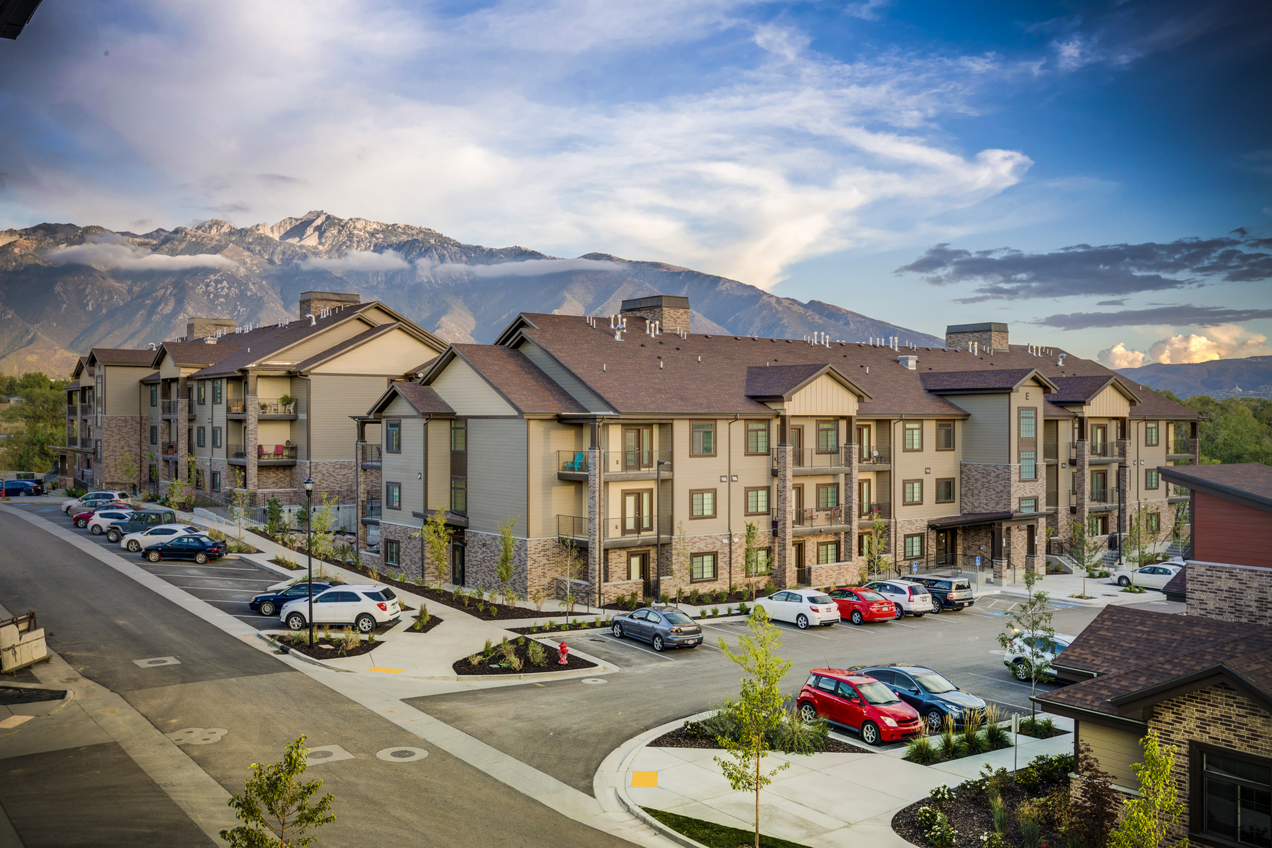 Charming apartment complex with modern design nestled at the base of scenic mountains, offering serene views and a welcoming atmosphere.