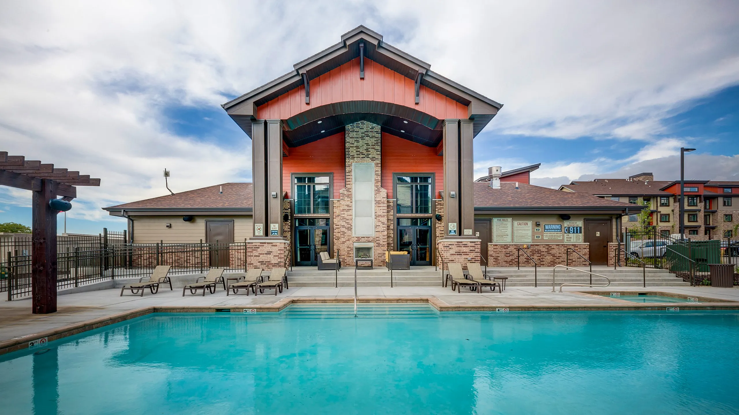 Luxurious apartment complex featuring a sparkling pool and elegant clubhouse with modern architecture.
