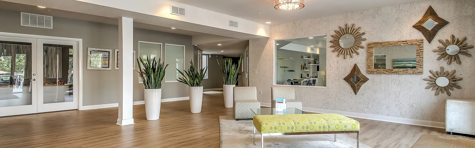 Elegant apartment lobby featuring modern decor, stylish seating, and lush indoor plants, creating a welcoming and luxurious atmosphere.