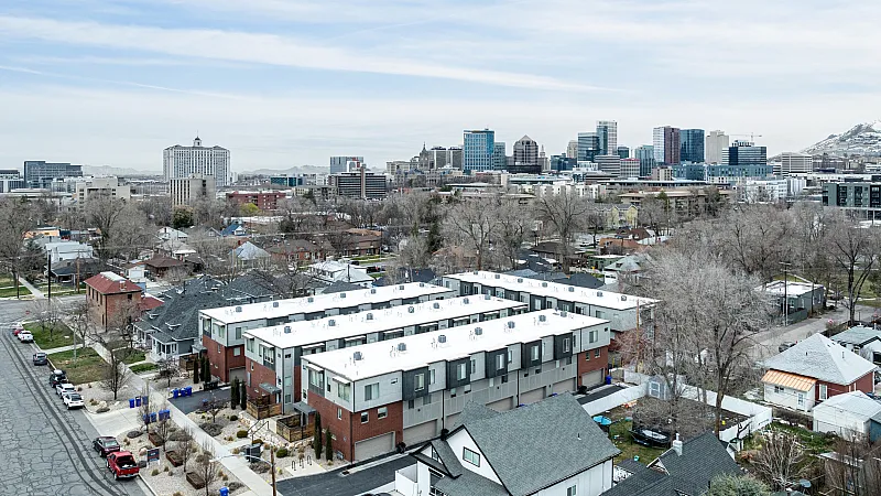 Panoramic view showcasing modern townhouses with a vibrant city skyline backdrop, offering urban living with scenic surroundings.
