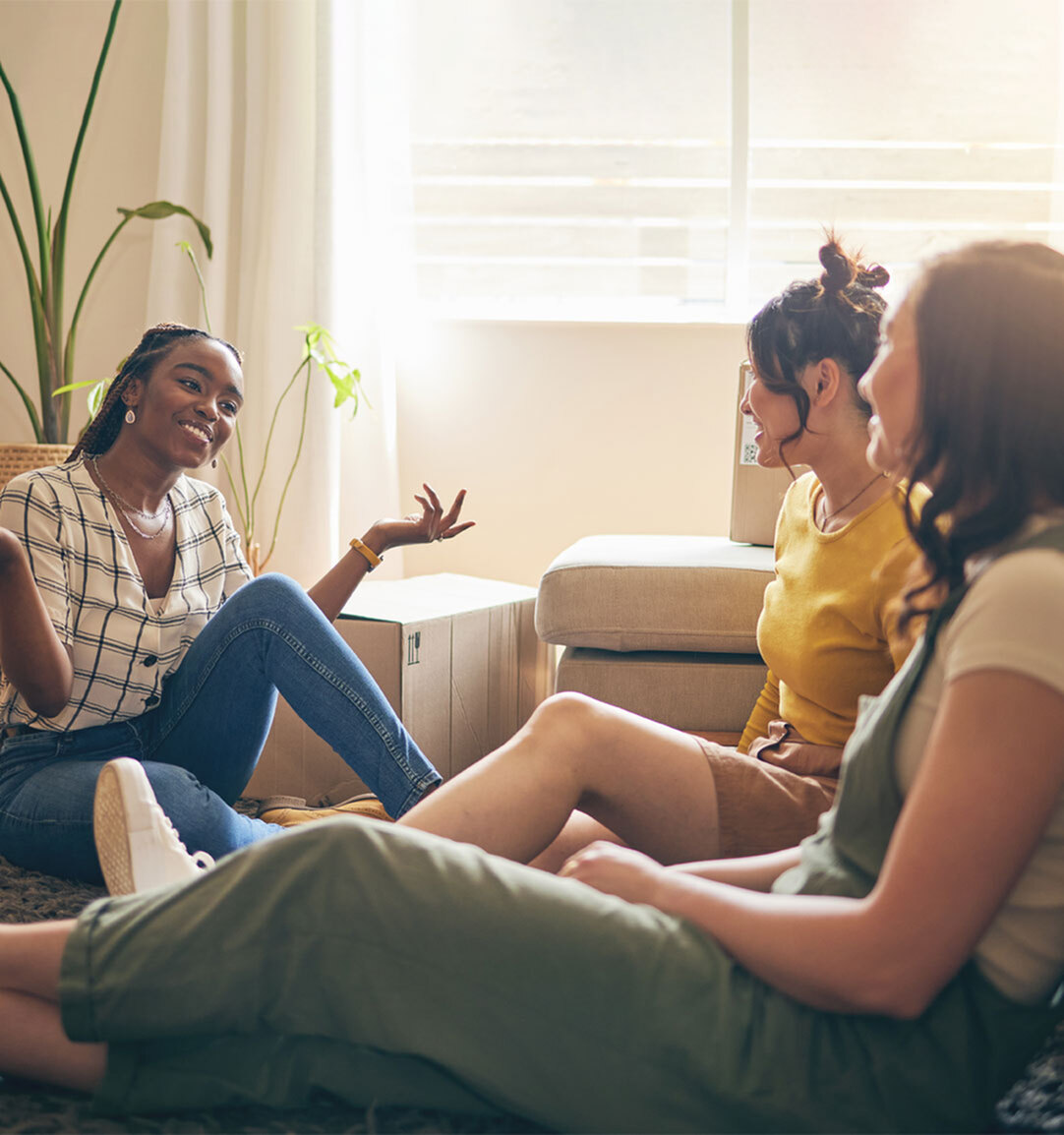 Warm and inviting living room space with friends enjoying a relaxed conversation, filled with natural light and cozy seating.
