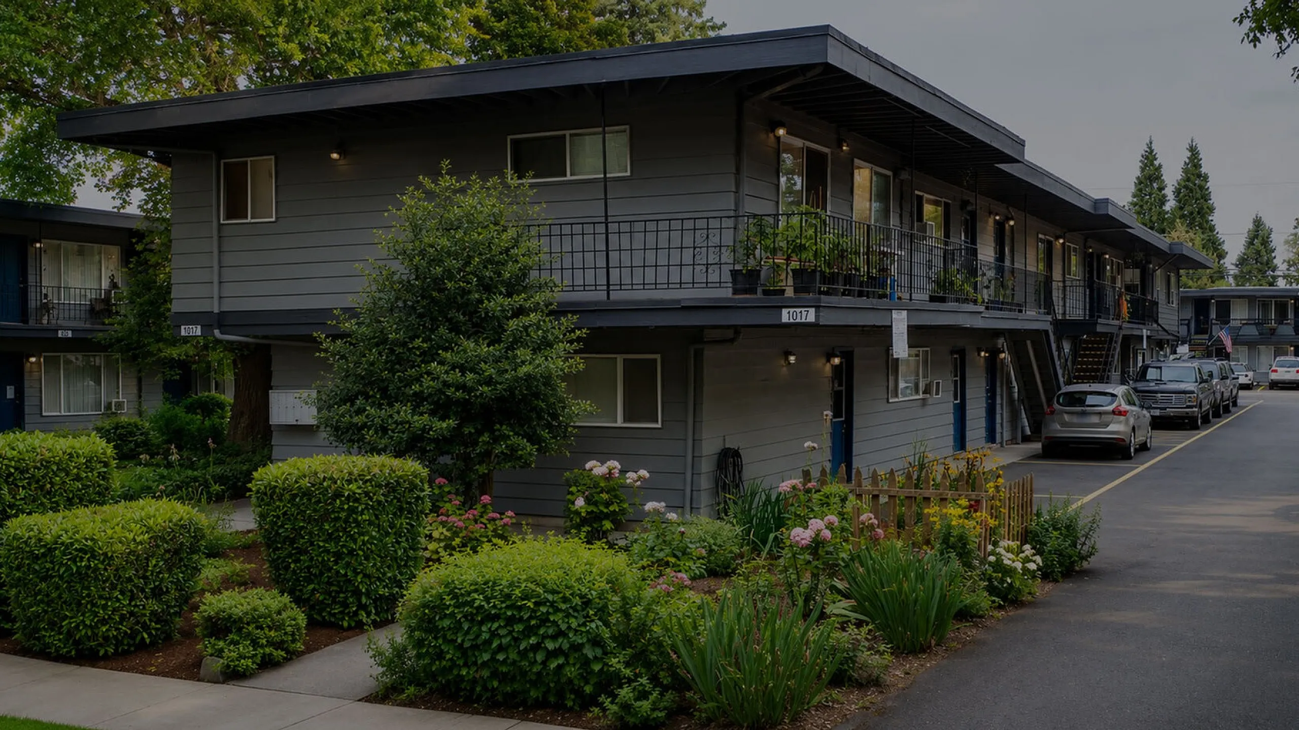Charming apartment complex with lush landscaping and modern architecture, offering a serene living environment.