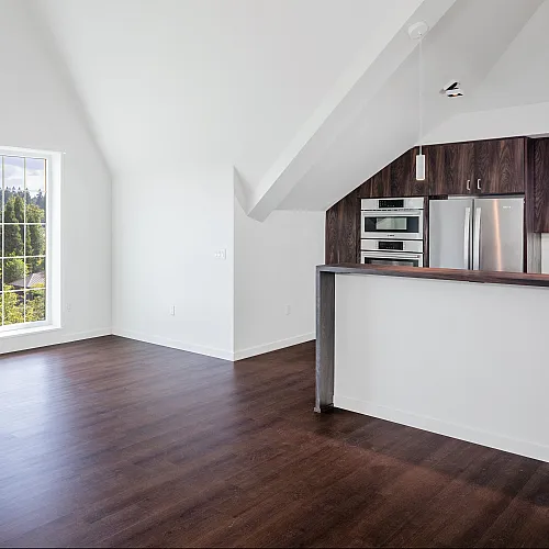 Bright and spacious room with large windows and modern kitchen.