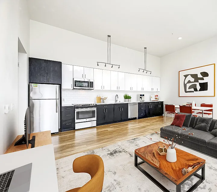 Chic open-concept living space featuring a modern kitchen with sleek cabinets, elegant dining area, and cozy seating with stylish decor.