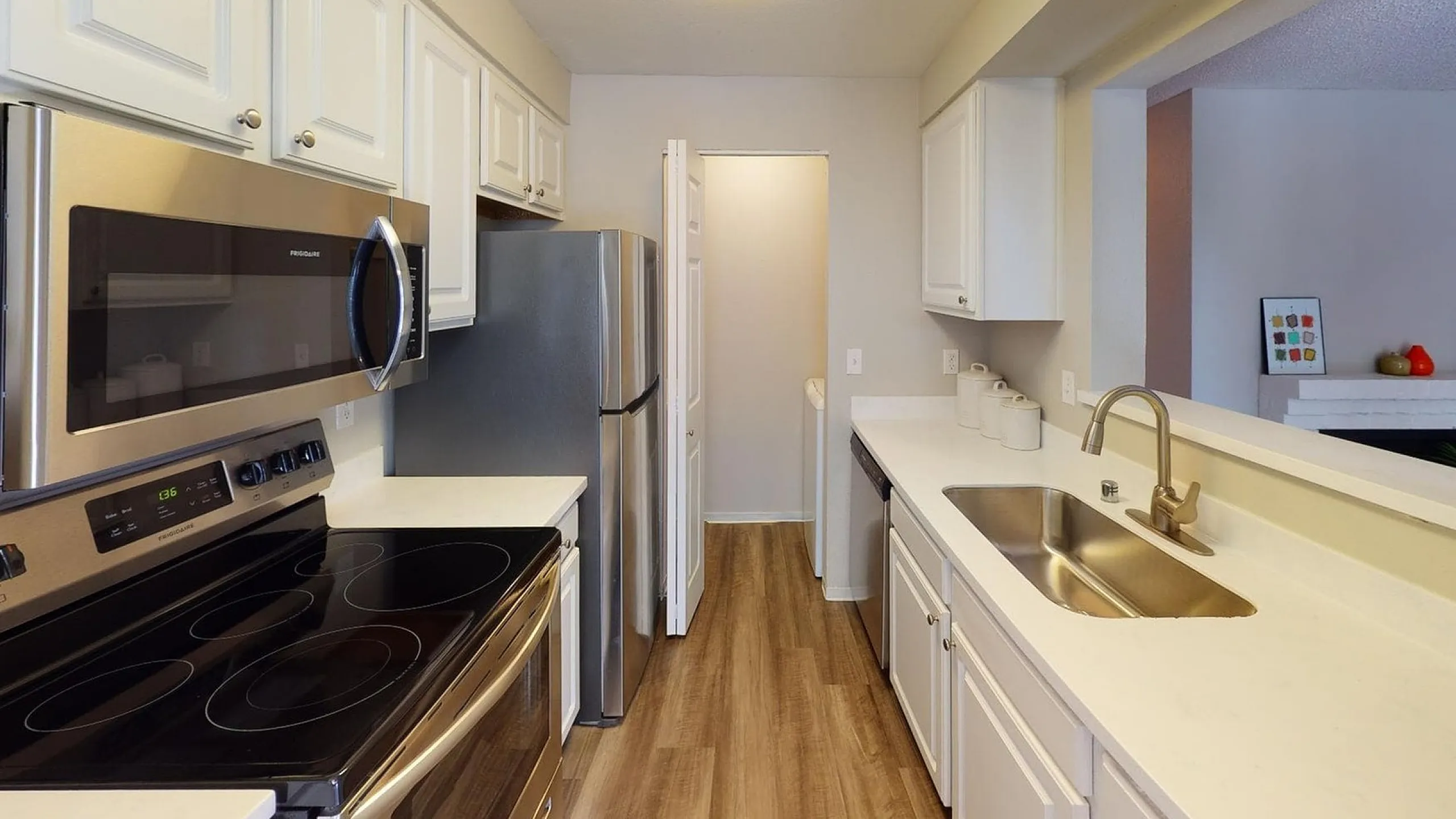 Modern kitchen with stainless steel appliances, sleek countertops, and an inviting open view to the living room.