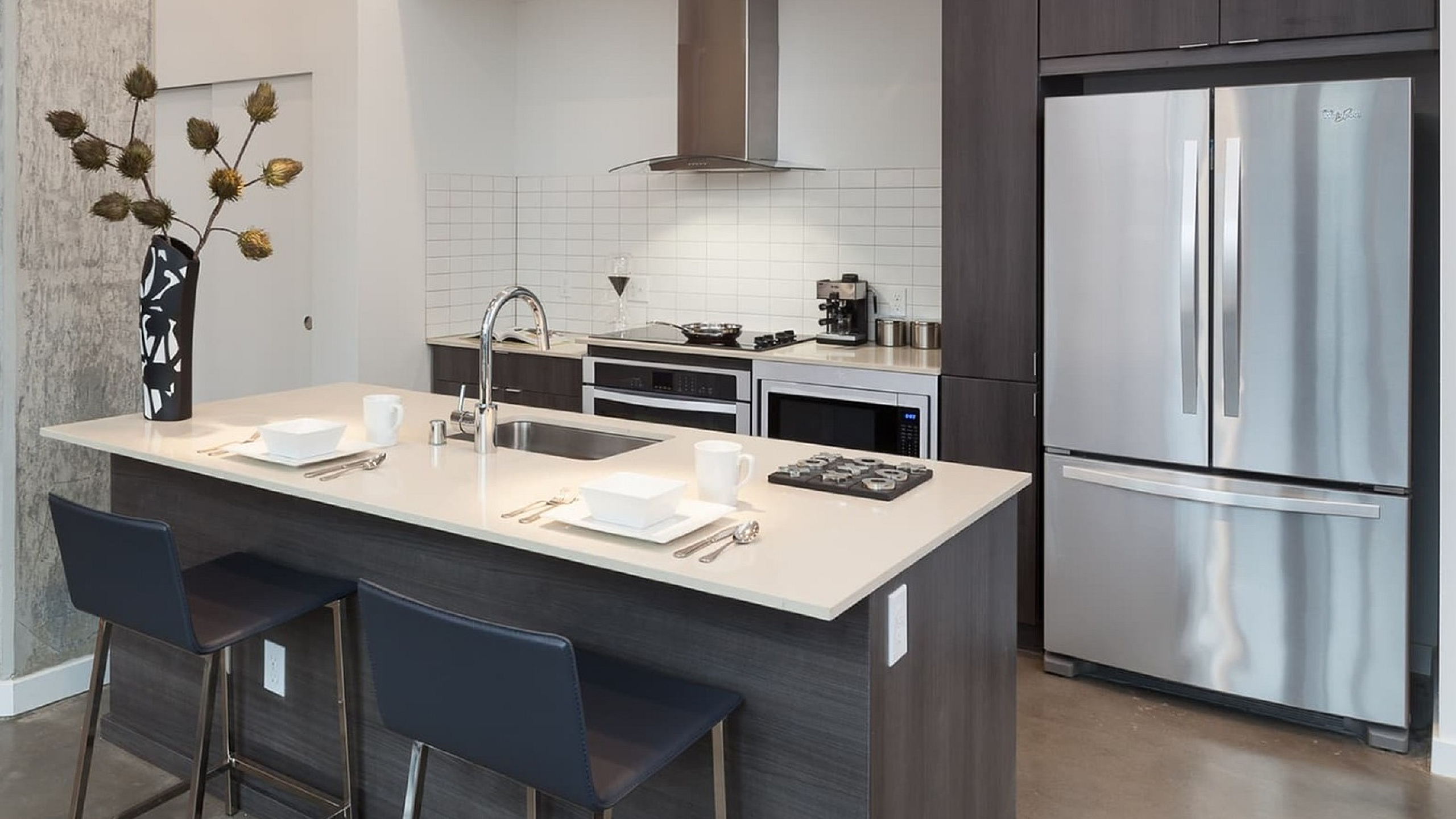 Modern kitchen design with sleek stainless steel appliances, stylish island with seating, and elegant pendant lighting.