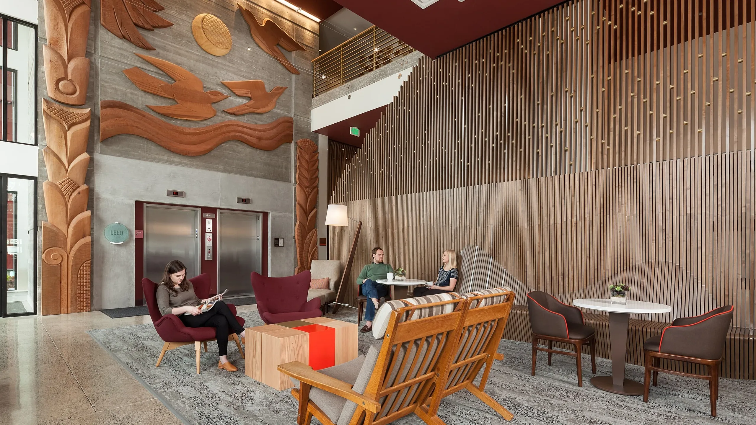Chic and inviting lobby area with modern wooden accents, stylish seating, and unique wall art, creating a perfect blend of comfort and aesthetics.
