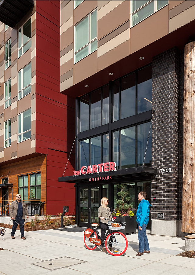 Modern urban apartment building exterior with stylish balconies and a vibrant community atmosphere, featuring a bike-sharing service outside.