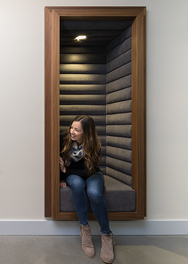 Two elegantly designed private seating alcoves with warm wooden frames, perfect for stylish and cozy office conversations.