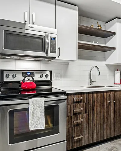 Modern kitchen with sleek stainless steel appliances, stylish wood cabinetry, and a contemporary design aesthetic.
