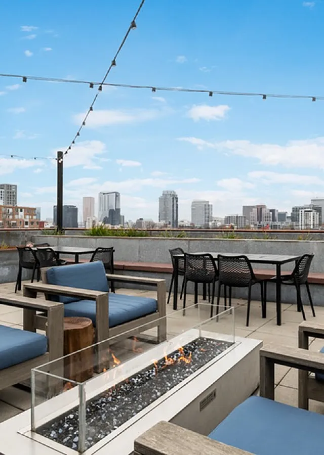 Stunning rooftop terrace with cozy seating, fire pit, and breathtaking city skyline views.