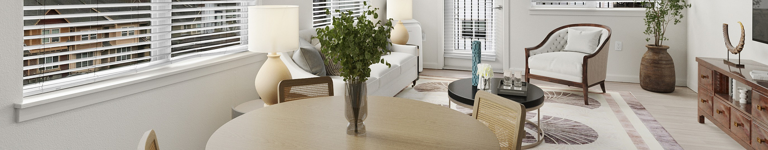 Bright and inviting living room featuring large windows, elegant decor, and a cozy dining area with sleek modern furnishings.