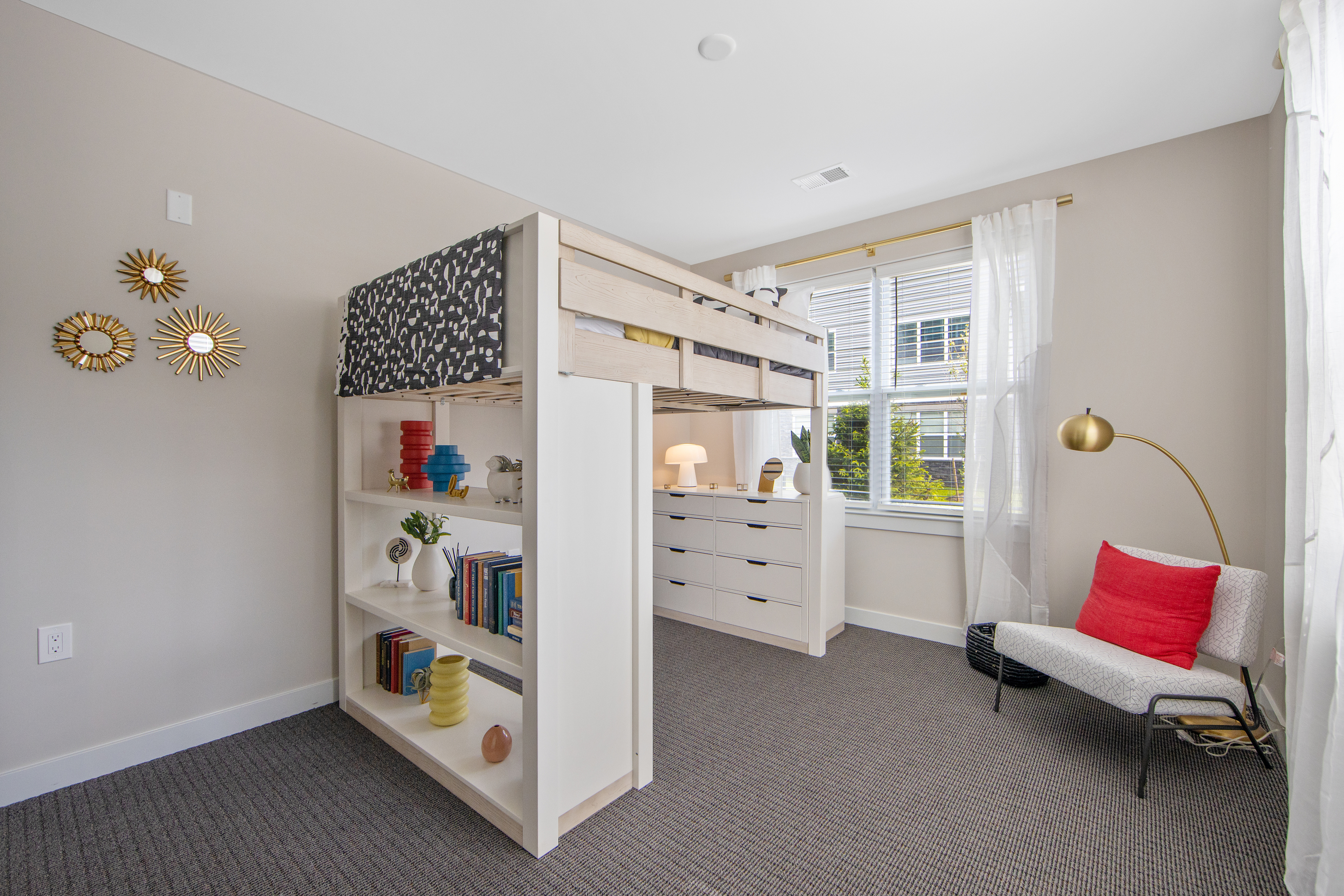 Charming bedroom with a stylish loft bed, built-in shelving, and a cozy reading nook under natural light.