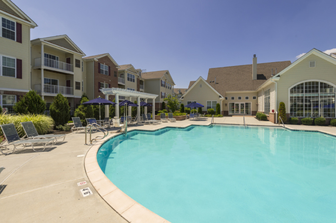 Inviting apartment complex with modern architecture and a sparkling outdoor pool, perfect for relaxation and social gatherings.