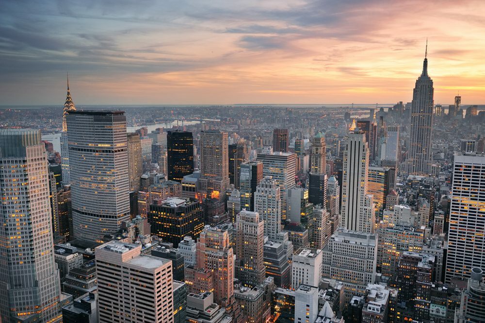 Breathtaking cityscape view of a vibrant skyline at sunset, showcasing iconic skyscrapers with a warm, glowing horizon.