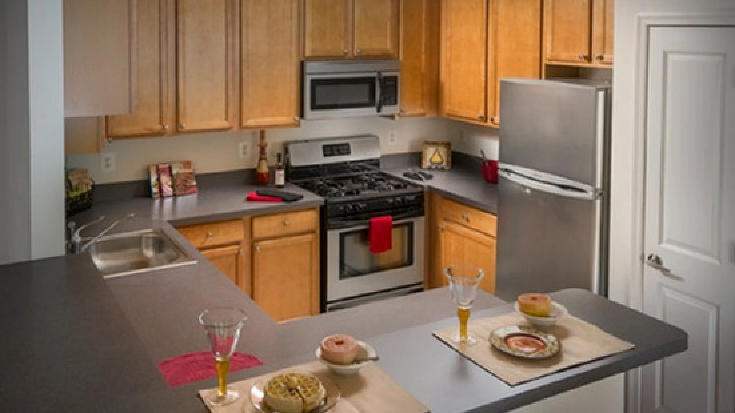 Modern kitchen with elegant wooden cabinets, sleek countertops, stainless steel appliances, and a cozy breakfast nook set for dining.