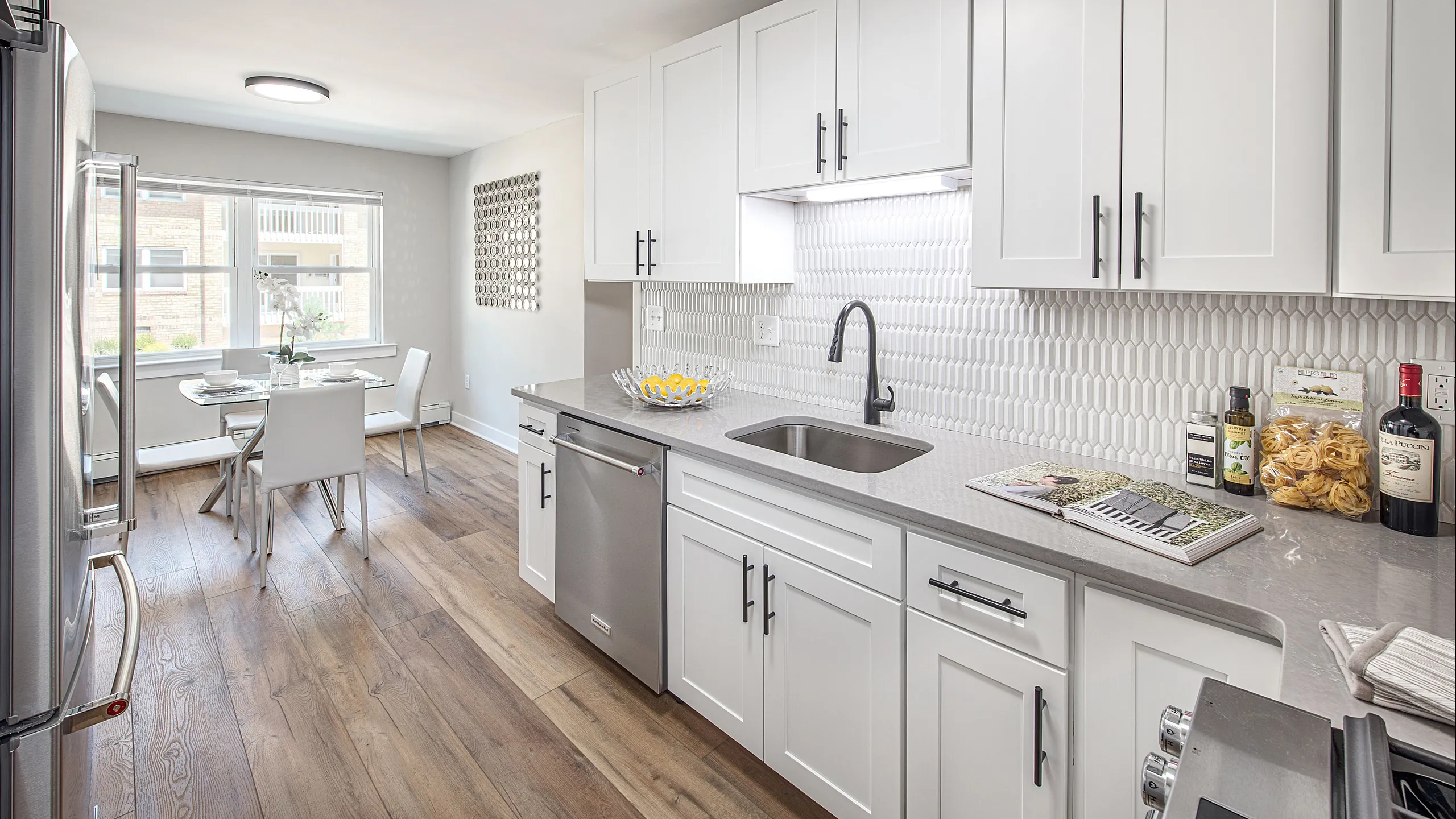 Bright, modern kitchen with sleek white cabinets, elegant countertops, and charming breakfast nook.