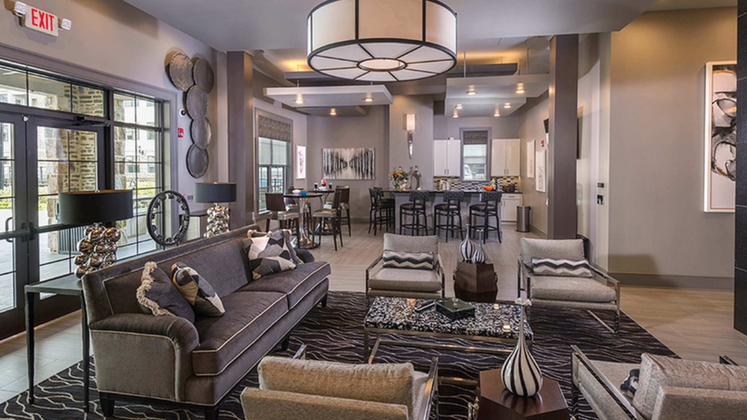 Chic and modern open-concept living area with stylish seating, elegant lighting, and a contemporary kitchen, creating a warm and inviting atmosphere.