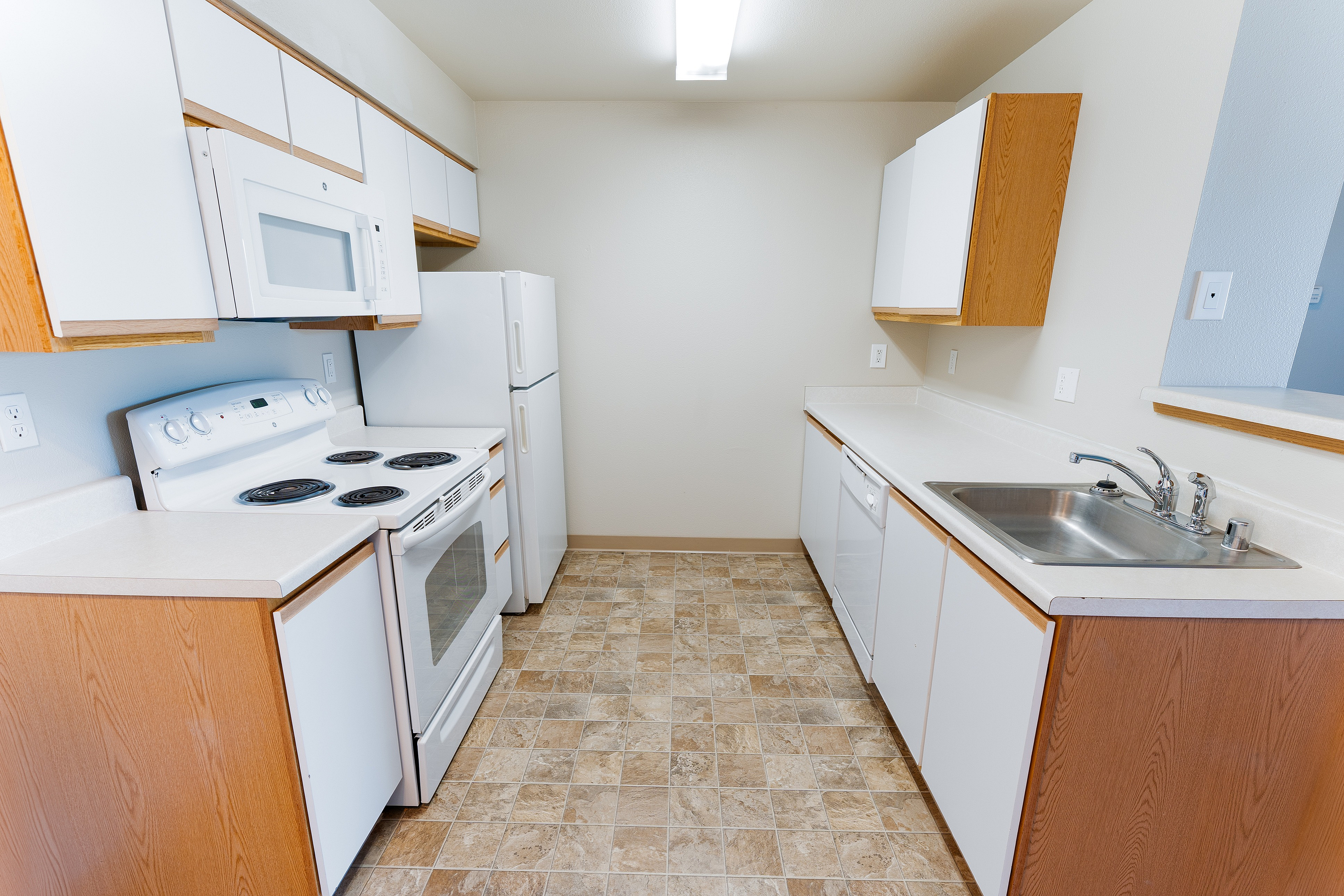 Modern kitchen with sleek white cabinets, spacious countertops, and fully equipped appliances.