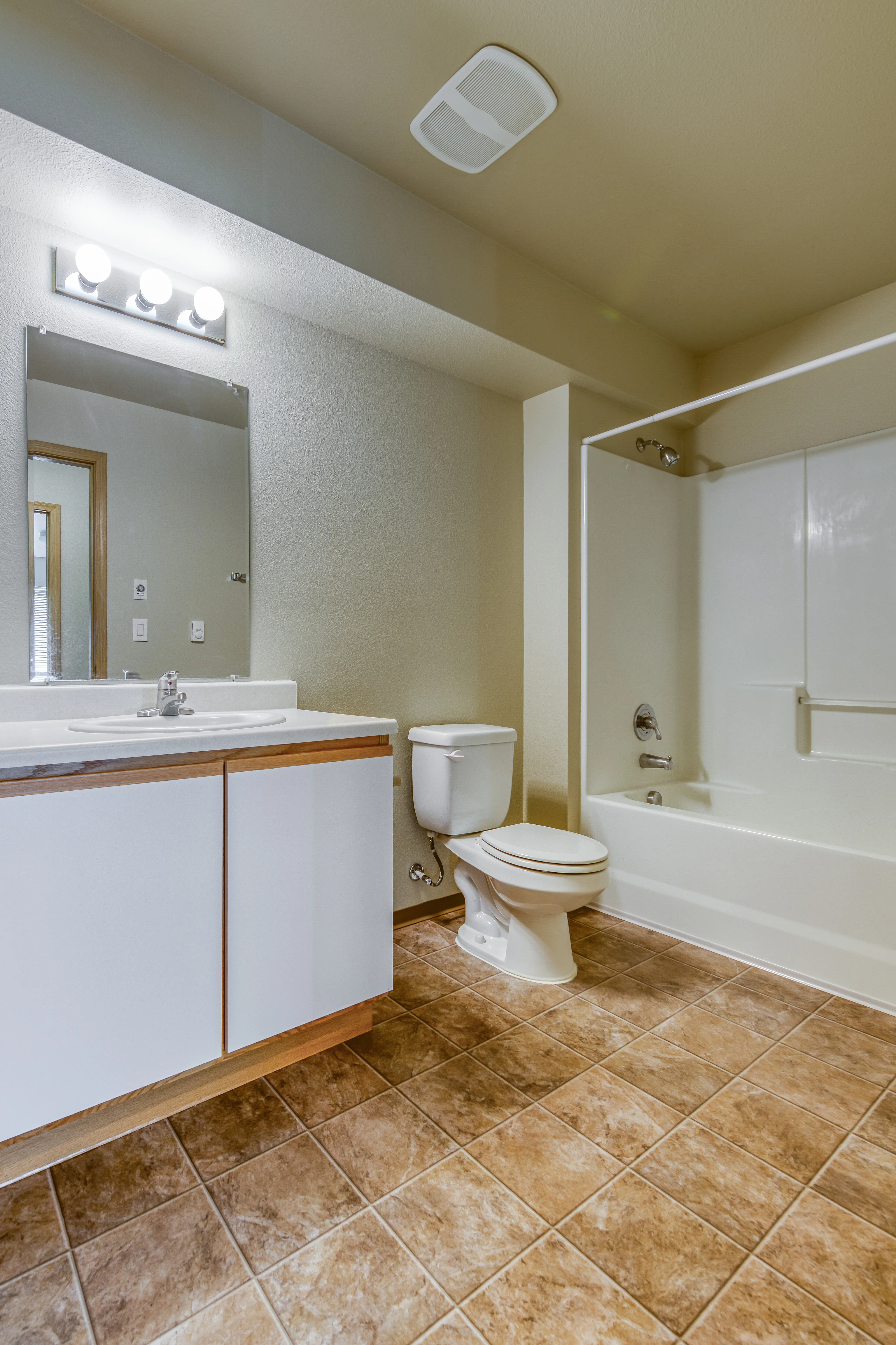 Modern bathroom with elegant tiling, sleek vanity, and a pristine bathtub, showcasing comfort and style.