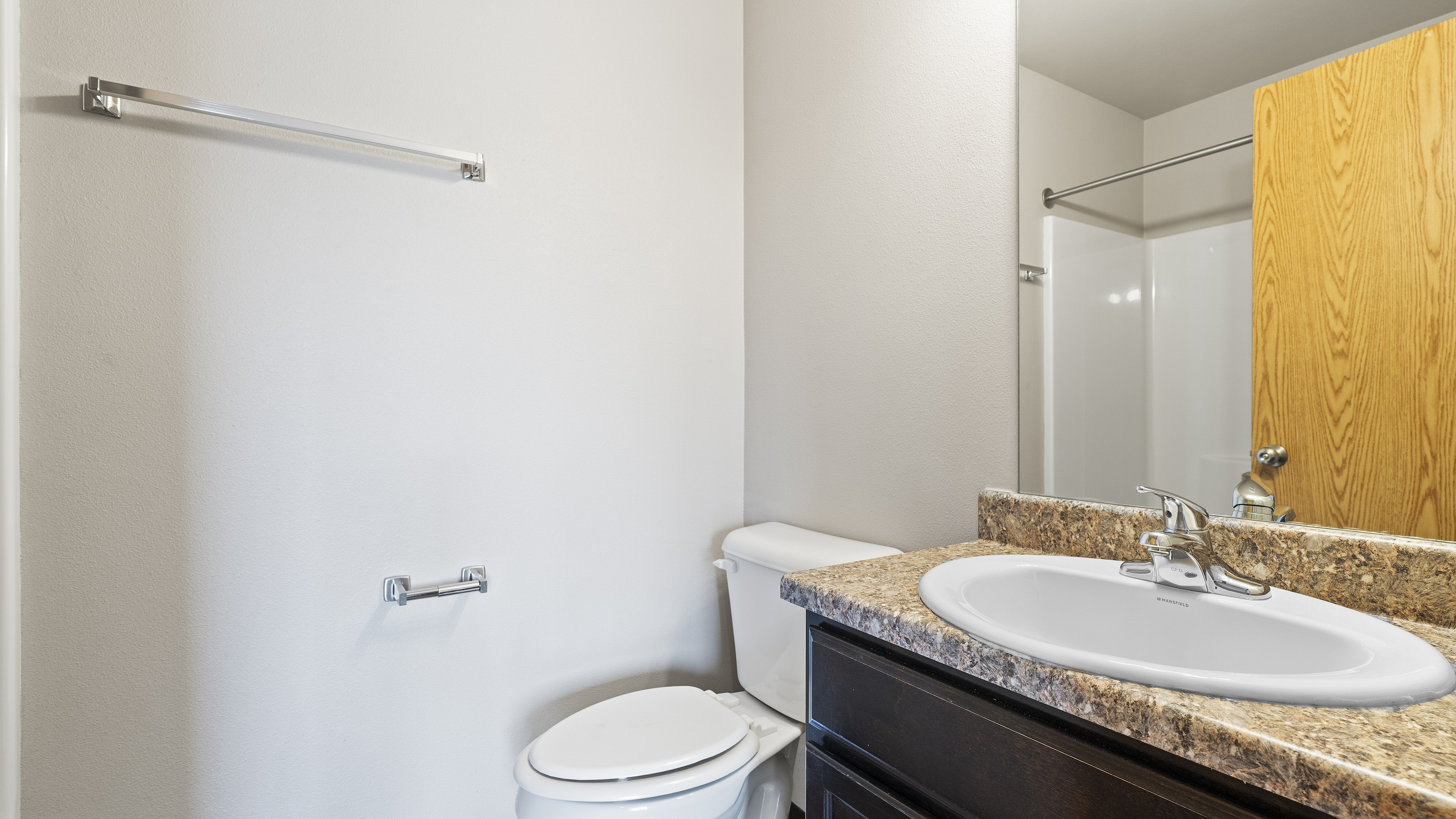 Modern bathroom with elegant granite countertop, sleek sink, and polished fixtures, ideal for a cozy apartment.