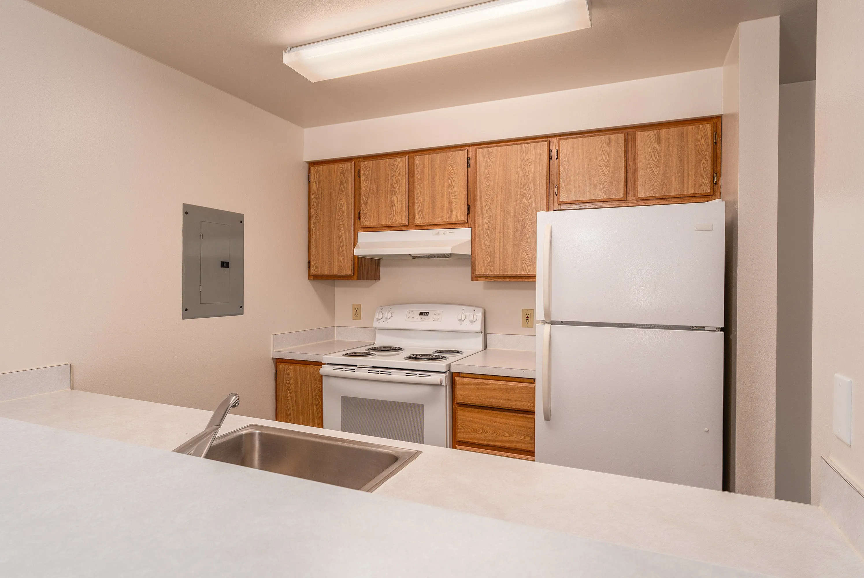 Inviting kitchen with modern appliances, sleek countertops, and warm wooden cabinetry. Perfect for culinary creativity.