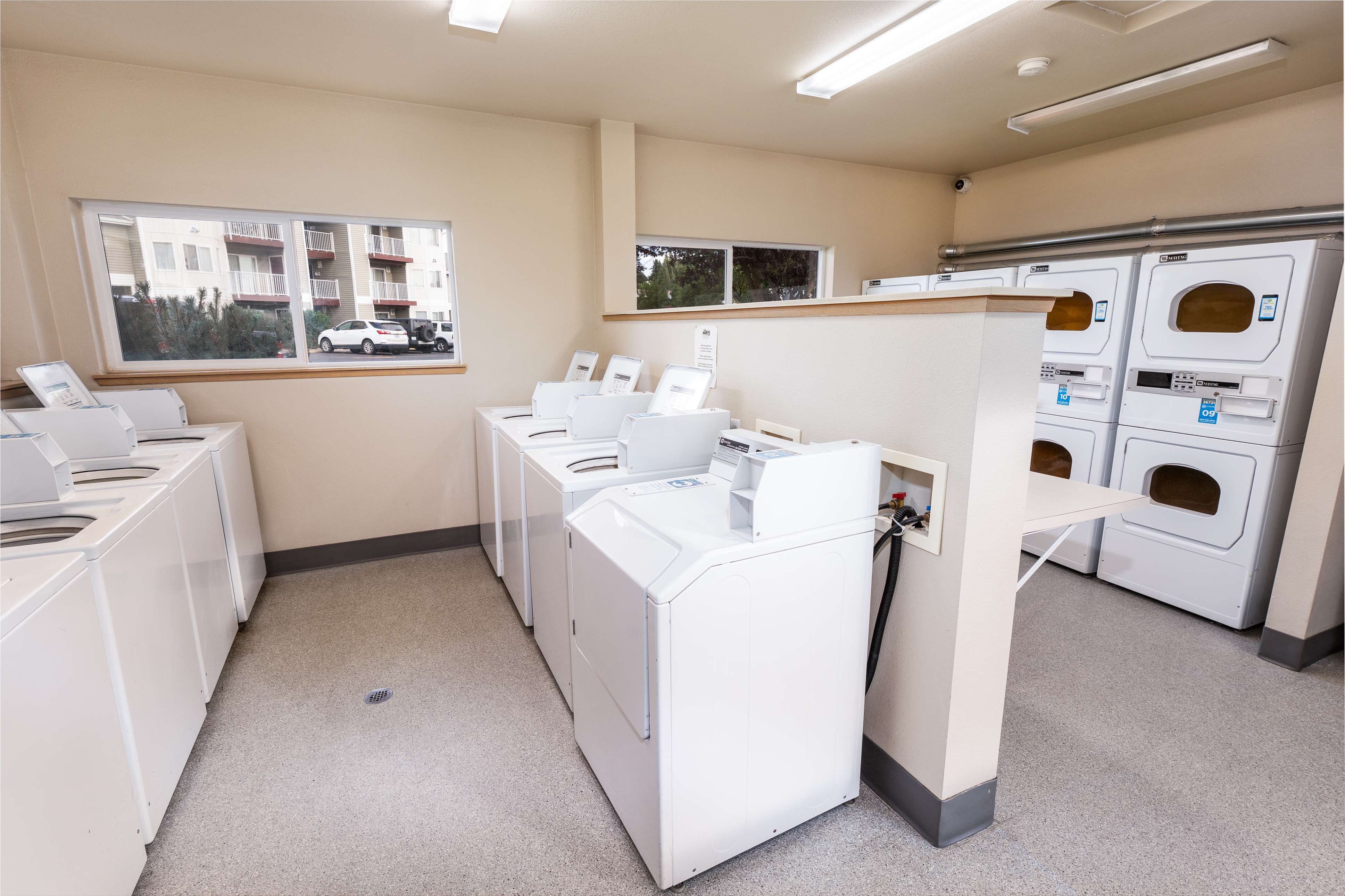 Modern communal laundry room with multiple washing machines and dryers, offering convenience and efficiency for residents.