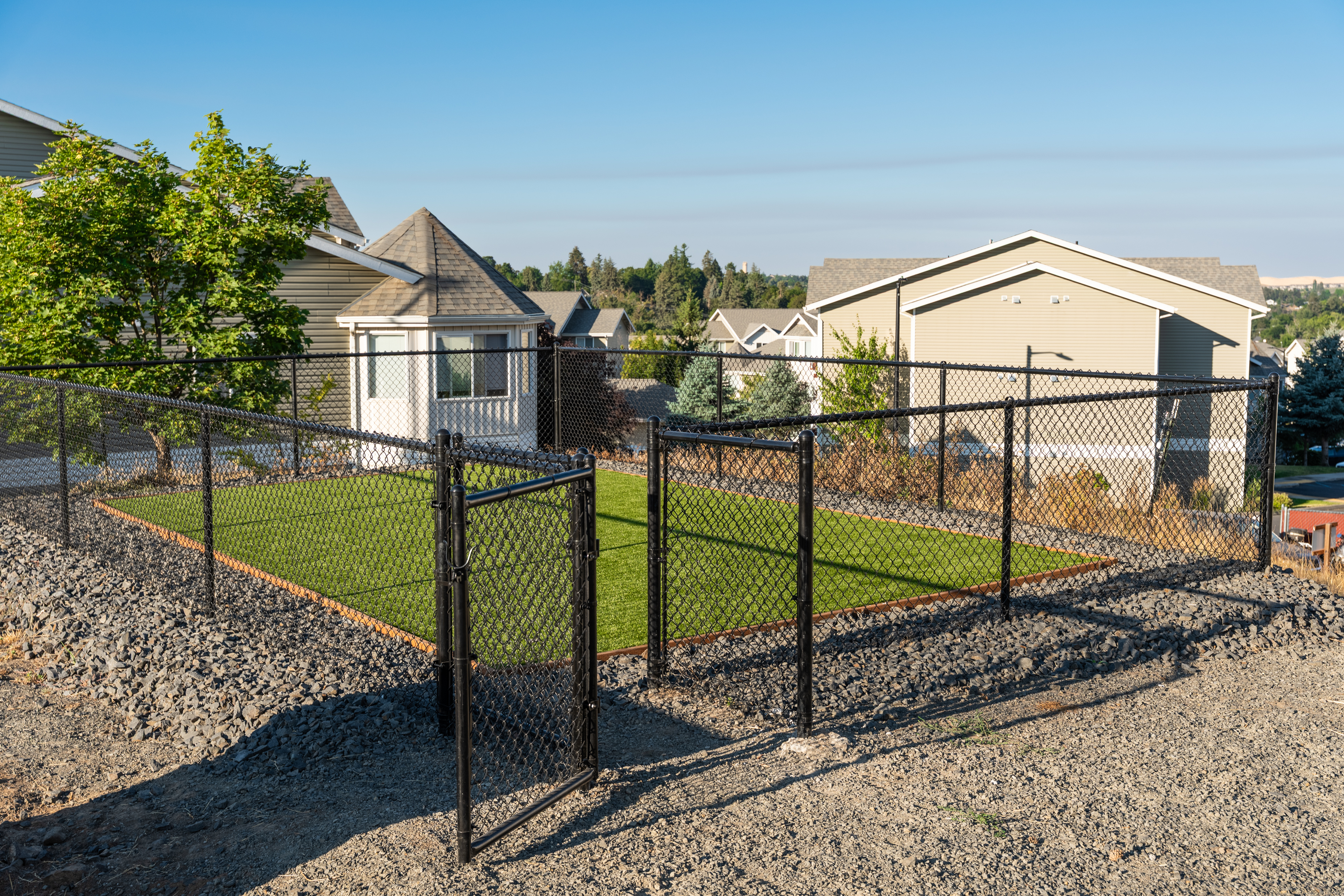 Charming fenced backyard with lush green lawn, set in a serene residential neighborhood with scenic views.