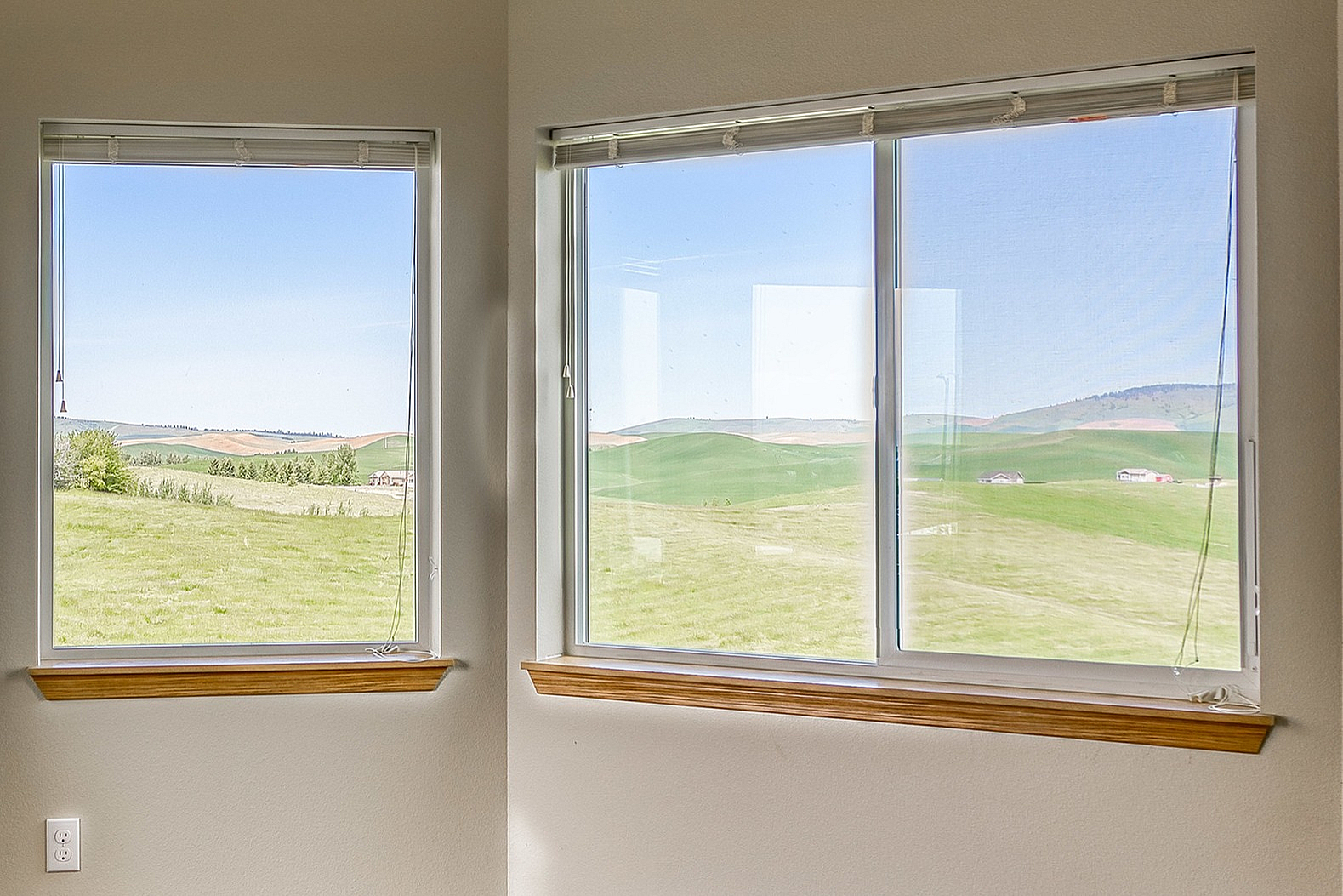 Bright room with large panoramic windows revealing a scenic landscape view, featuring elegant hardwood flooring and abundant natural light.