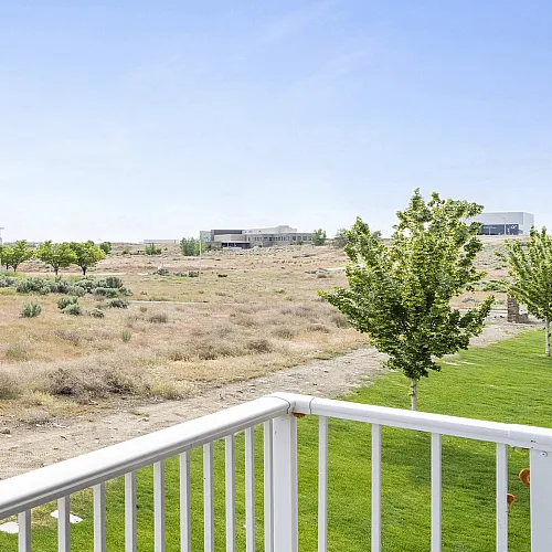 Beautiful balcony view showcasing an expansive open landscape with green trees under a clear blue sky, perfect for nature enthusiasts.