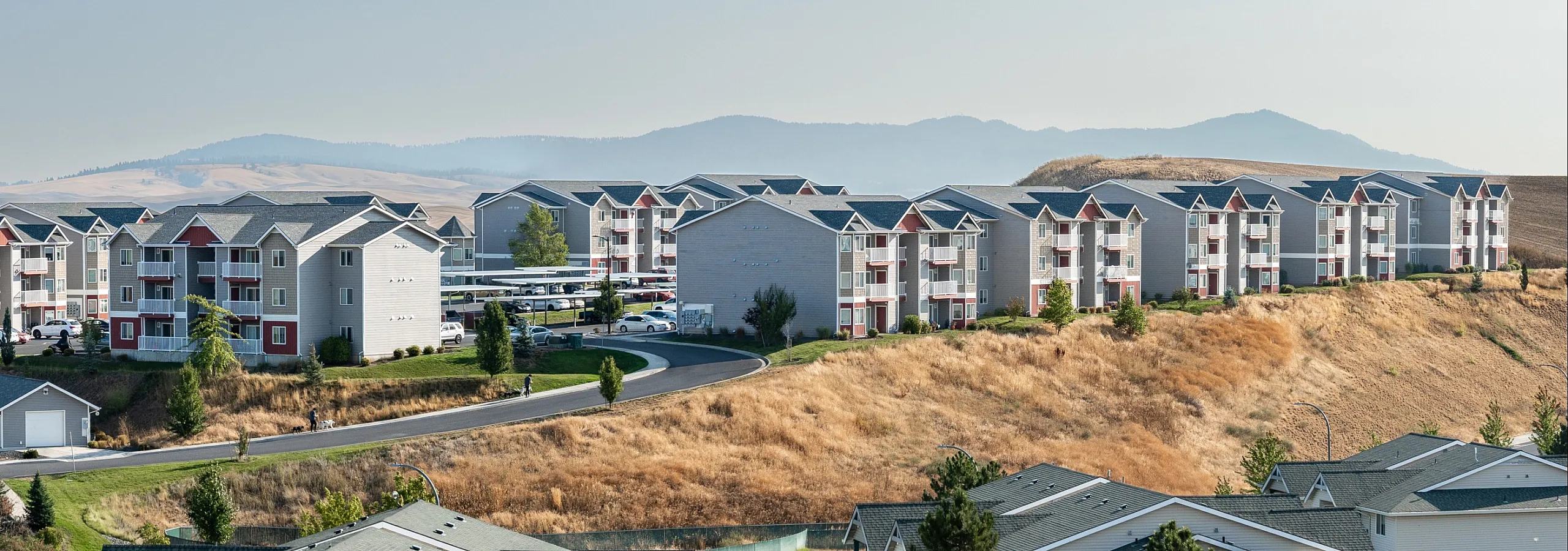 Beautiful hillside apartment complex offering scenic views, surrounded by lush greenery and sweeping landscapes.