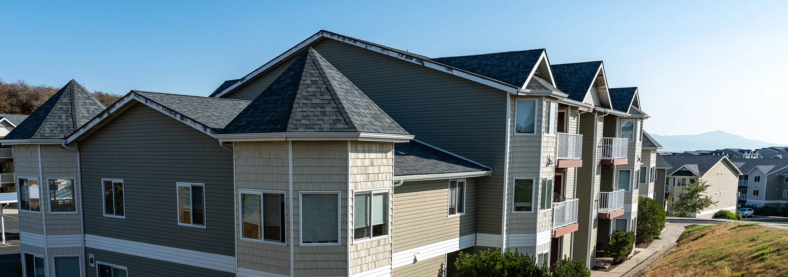 Charming apartment complex with modern design, featuring lush landscaping and scenic views, perfect for comfortable living.