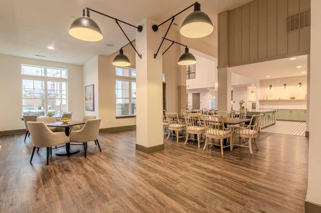 Inviting open area with stylish dining tables, elegant chairs, and modern lighting fixtures in a bright, spacious setting.