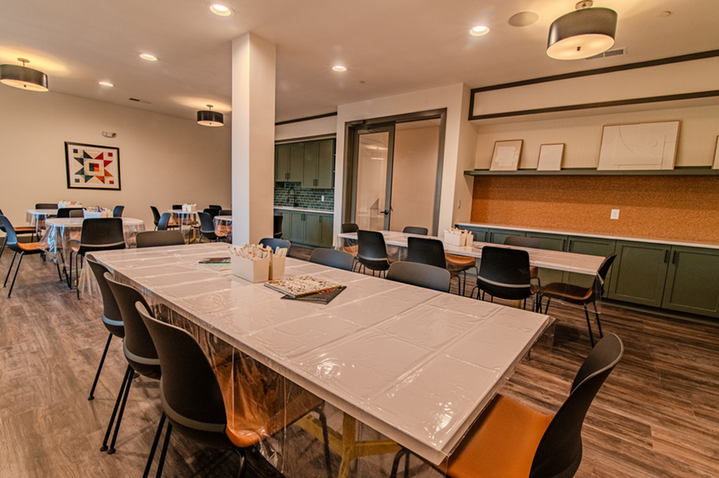Inviting community room with sleek tables, comfortable chairs, modern lighting, and stylish decor.