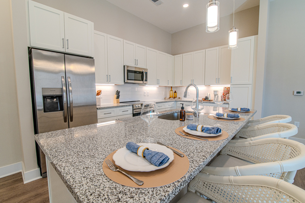 Luxurious kitchen with granite countertops, stainless steel appliances, and stylish bar seating.
