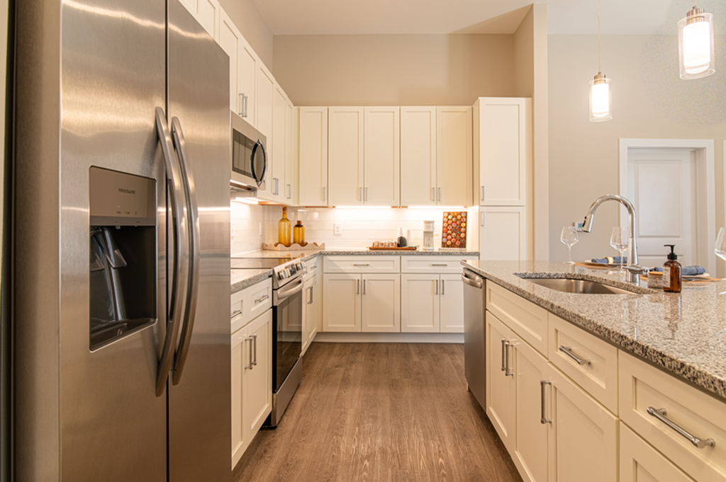 Elegant kitchen with granite countertops, stainless steel appliances, and warm lighting.