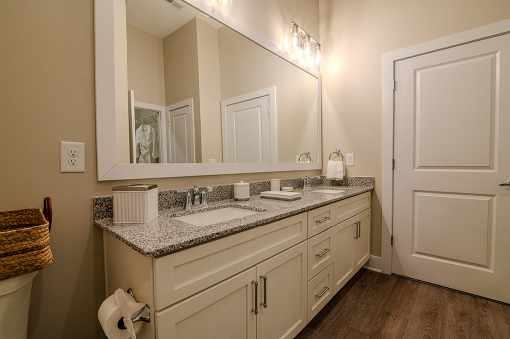 Stylish bathroom featuring a large mirror, double sinks, and granite countertops.