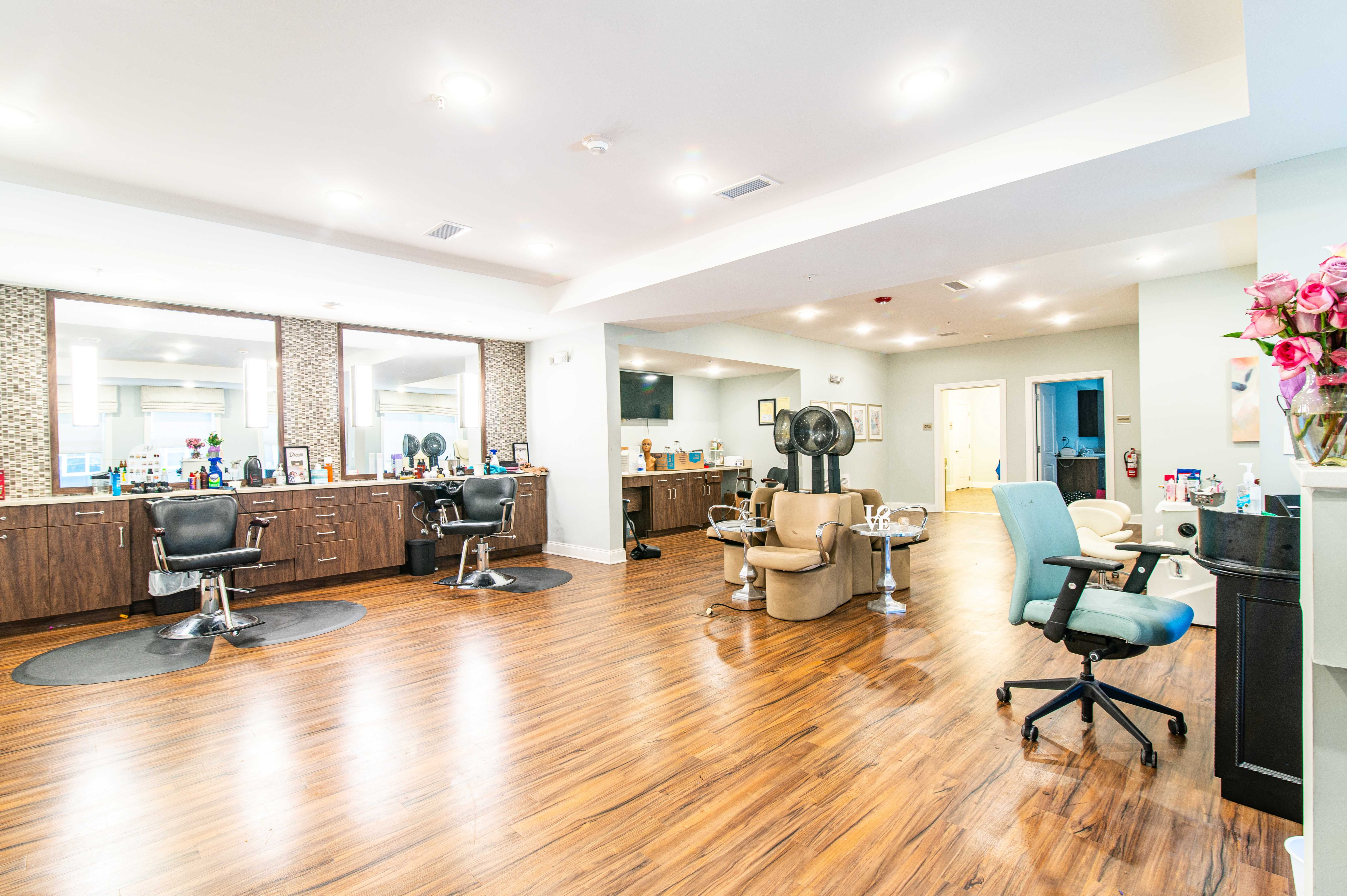 Bright and inviting hair salon with modern styling chairs, elegant wood flooring, and chic decor, perfect for a luxurious pampering experience.