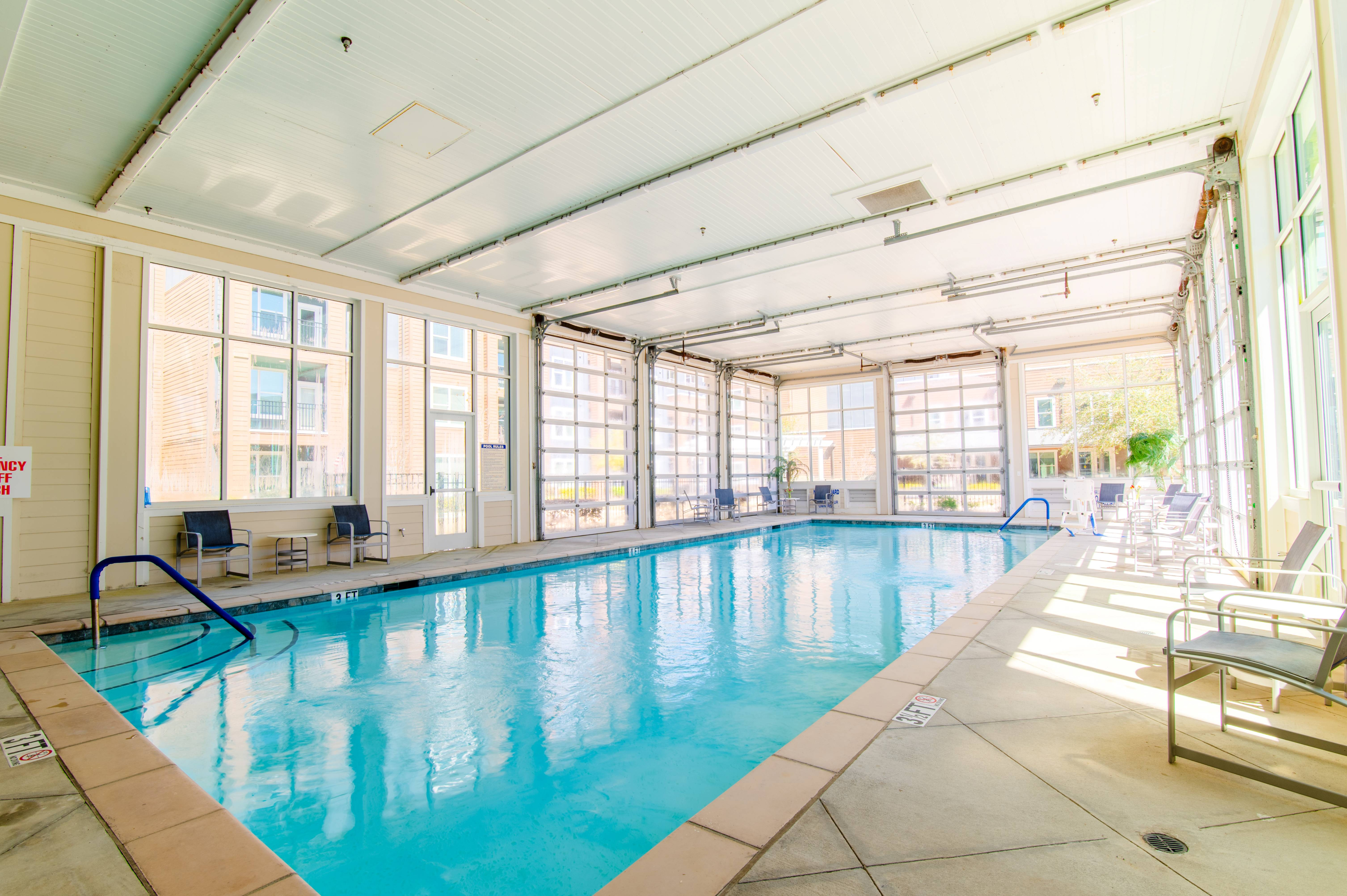 Bright and inviting indoor pool area with sunlit windows and comfortable seating, perfect for relaxation and leisure.