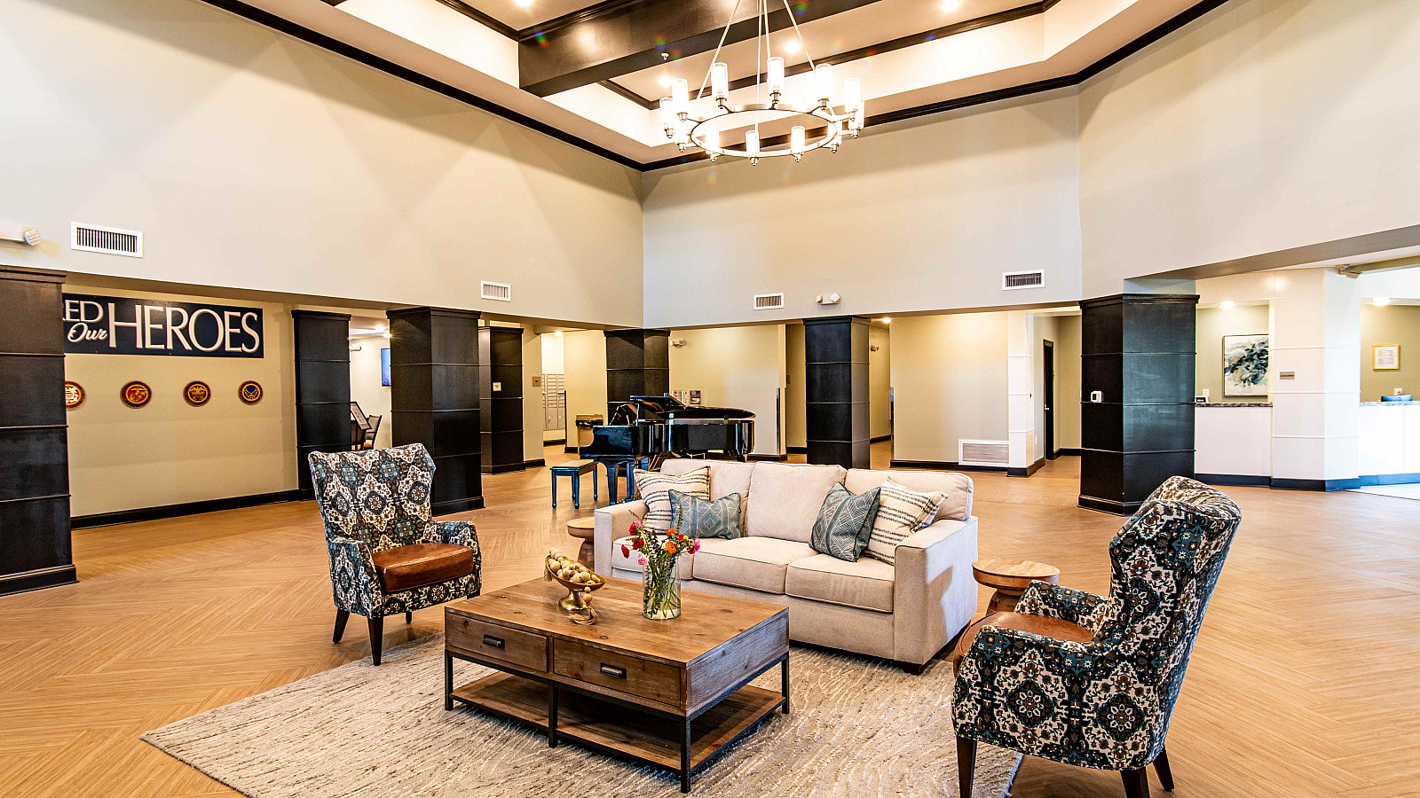Elegant and spacious lobby with high ceilings, luxurious chandelier, and plush seating area, featuring a grand piano and stylish decor.