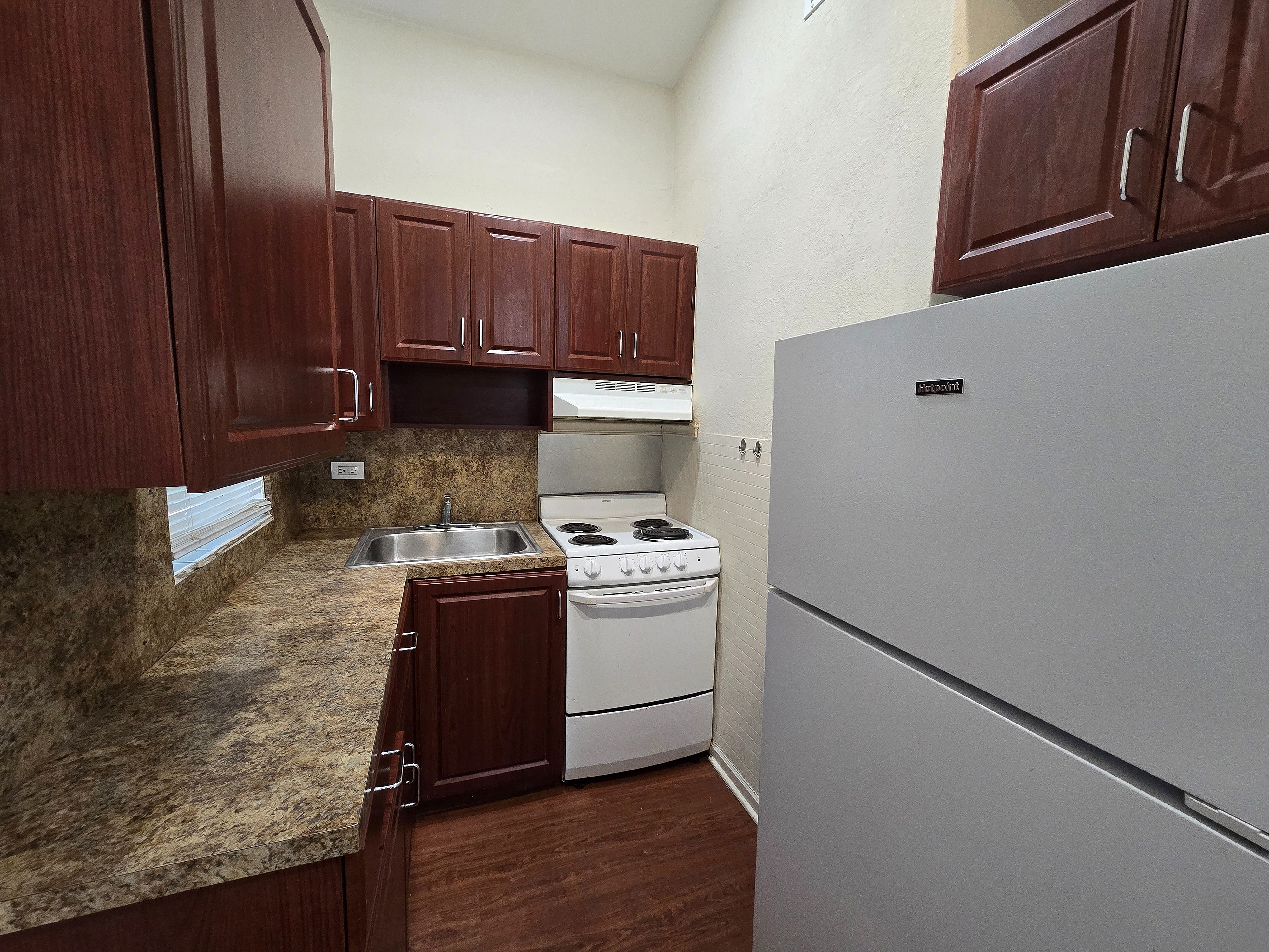 Charming kitchen featuring elegant wooden cabinets, sleek countertops, and modern appliances.